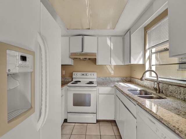 kitchen featuring white appliances, sink, light tile patterned floors, light stone counters, and white cabinetry