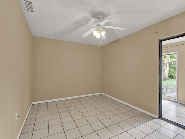 empty room with ceiling fan, light tile patterned floors, and a textured ceiling