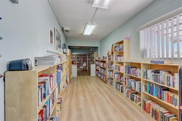 interior space with wooden walls, wood-type flooring, and a textured ceiling