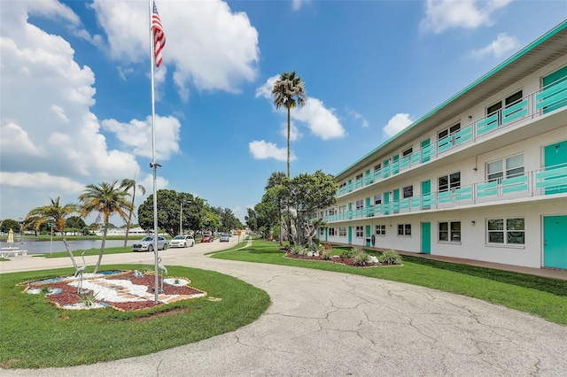 surrounding community with a water view and a yard