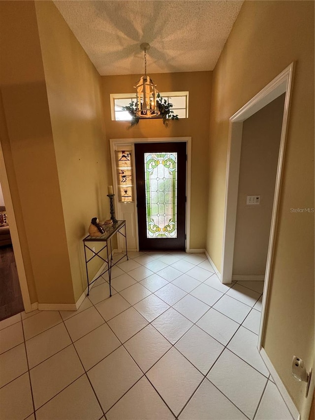 foyer with light tile patterned floors, a chandelier, and a textured ceiling