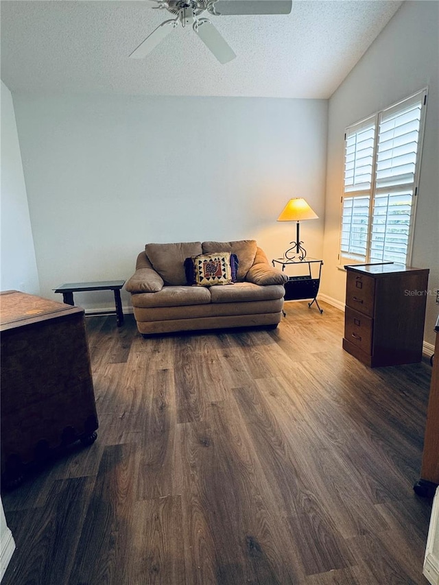 living room with a textured ceiling, dark hardwood / wood-style flooring, ceiling fan, and lofted ceiling