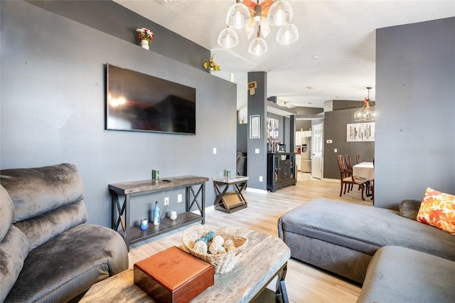 living room with light hardwood / wood-style floors and a chandelier