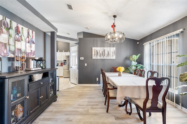 dining space with beverage cooler, lofted ceiling, a notable chandelier, and light hardwood / wood-style floors