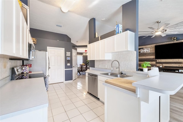 kitchen featuring white cabinetry, sink, appliances with stainless steel finishes, kitchen peninsula, and a breakfast bar area