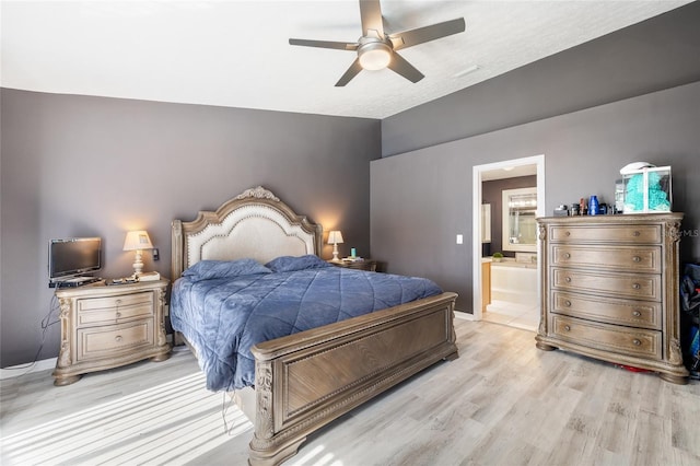 bedroom with ceiling fan, connected bathroom, and light hardwood / wood-style flooring