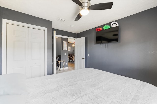 bedroom with hardwood / wood-style floors, ceiling fan, and a closet