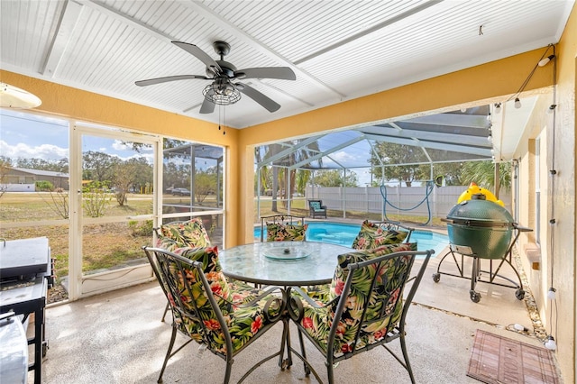 sunroom with ceiling fan, a swimming pool, and vaulted ceiling