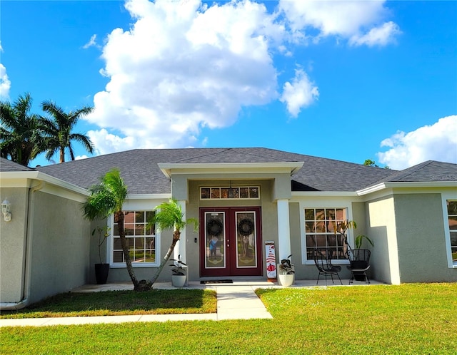 property entrance with french doors and a lawn