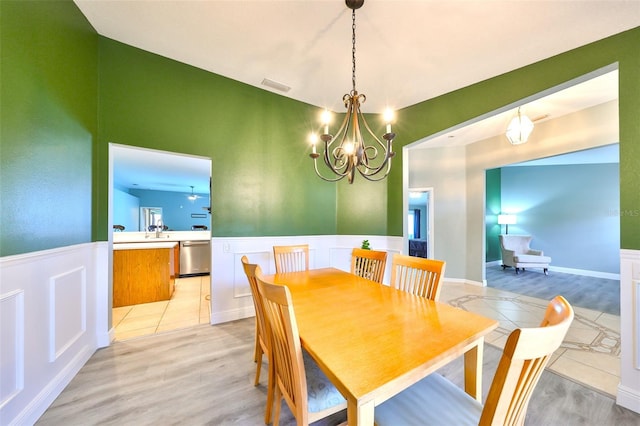 dining room featuring a chandelier, light wood-type flooring, and sink