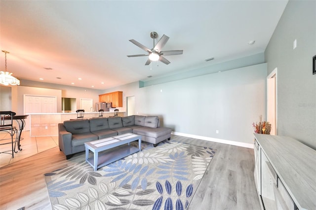 living room featuring ceiling fan and light wood-type flooring