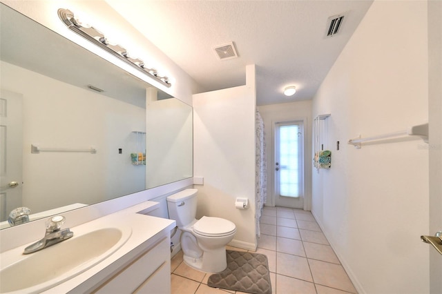 bathroom featuring toilet, a textured ceiling, vanity, and tile patterned floors