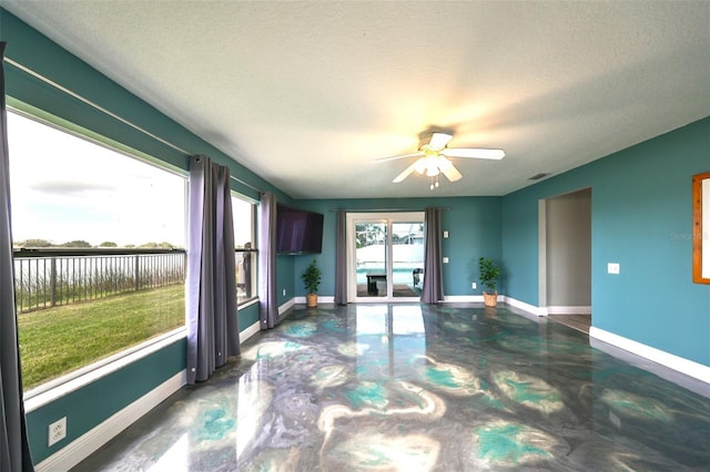 interior space featuring ceiling fan and a textured ceiling