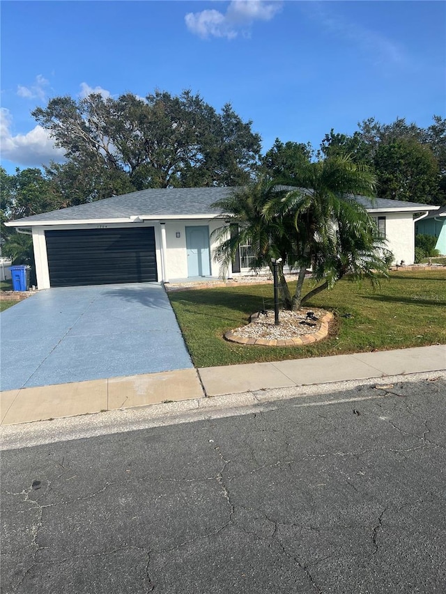 single story home featuring a garage and a front lawn