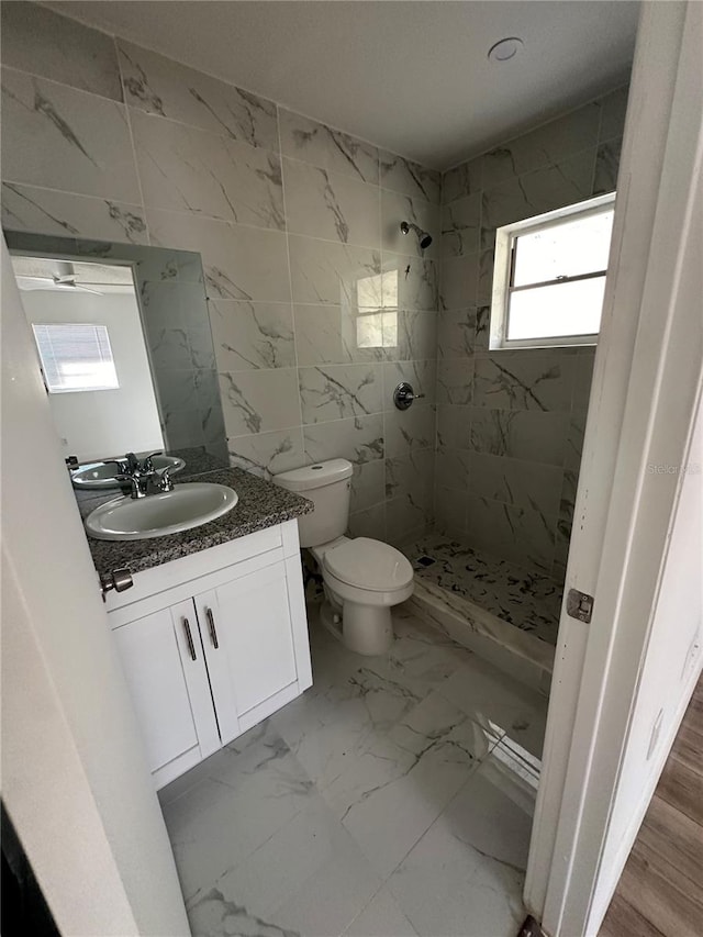 bathroom featuring toilet, vanity, hardwood / wood-style floors, and tiled shower