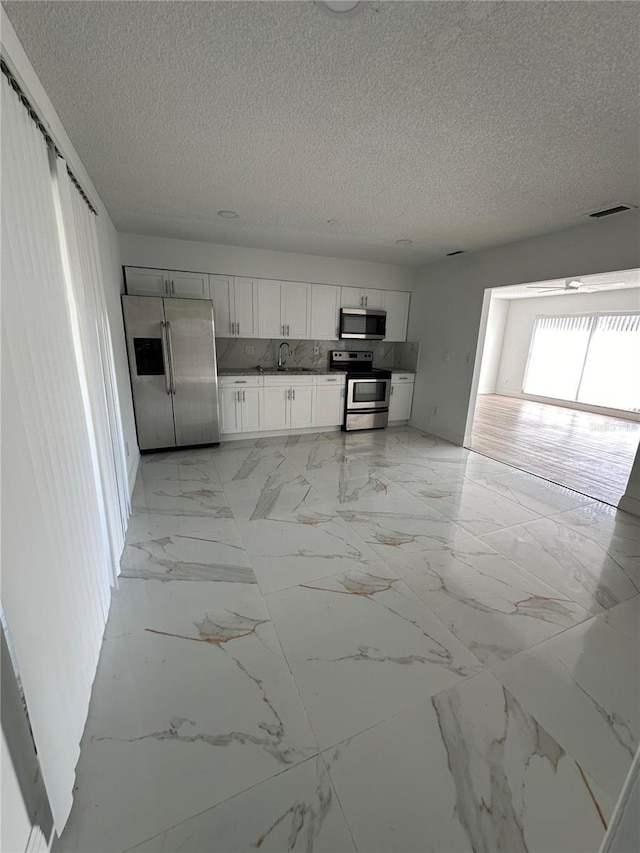 kitchen featuring white cabinets, a textured ceiling, sink, and appliances with stainless steel finishes