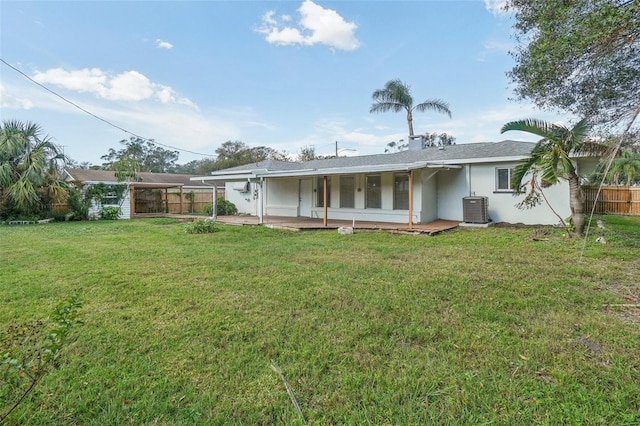 back of property with a yard and central air condition unit