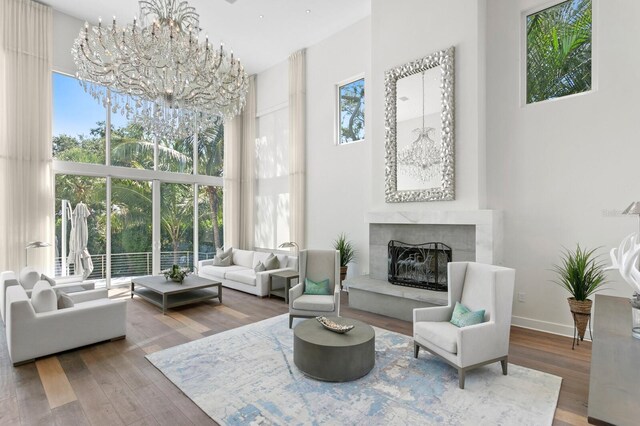 sitting room featuring hardwood / wood-style floors, a high ceiling, a wealth of natural light, and a chandelier