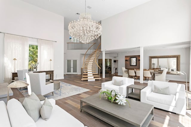 living room with dark hardwood / wood-style floors, a high ceiling, and an inviting chandelier