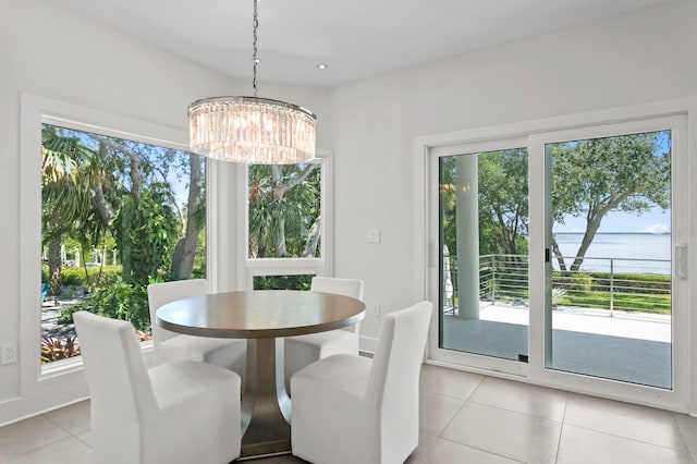 tiled dining area featuring plenty of natural light, a water view, and an inviting chandelier