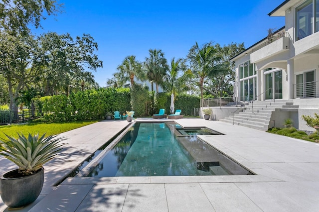 view of pool with a patio area and an in ground hot tub