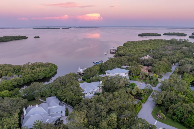 aerial view at dusk featuring a water view