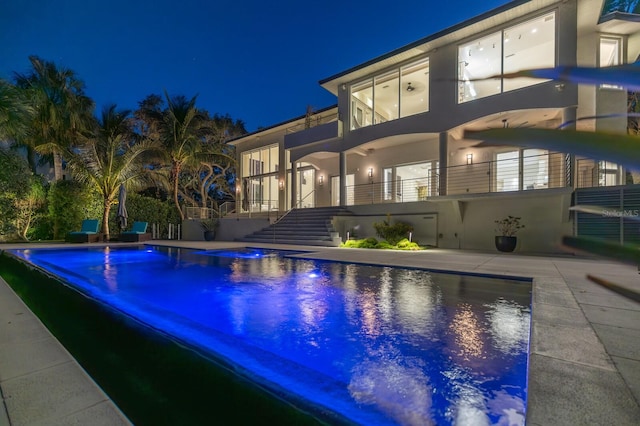 pool at twilight with a patio