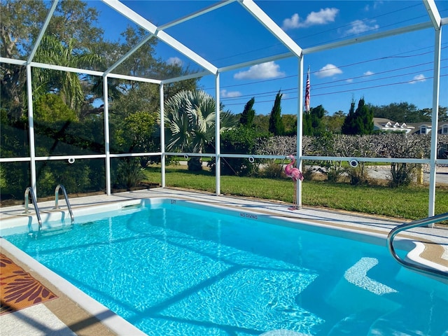 view of swimming pool featuring a lanai and a lawn