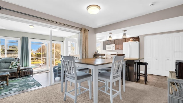 dining area featuring light carpet