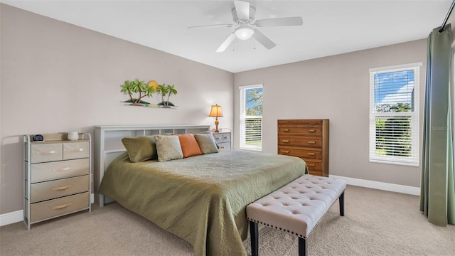 carpeted bedroom featuring multiple windows and ceiling fan