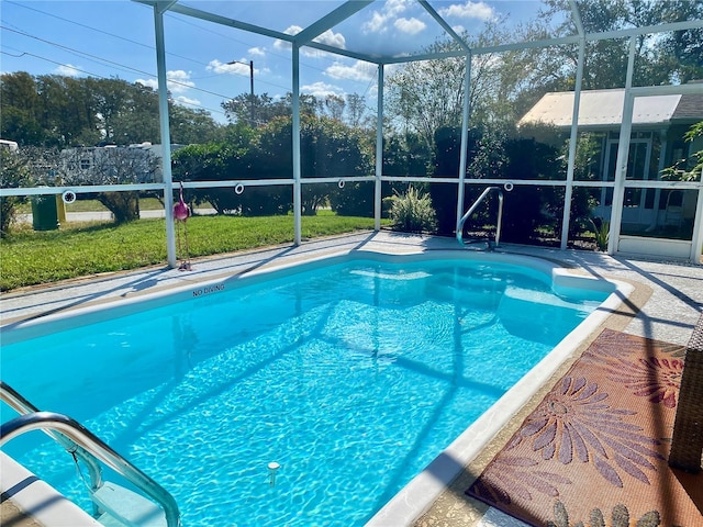 view of swimming pool with a yard and a lanai