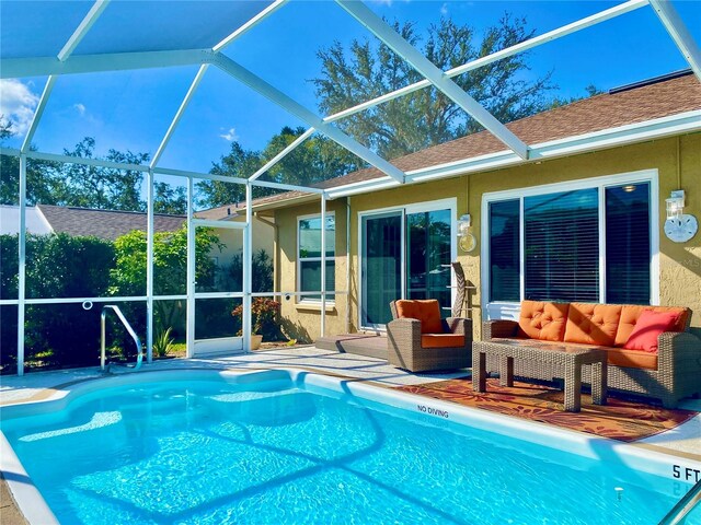 view of swimming pool with a patio, outdoor lounge area, and glass enclosure