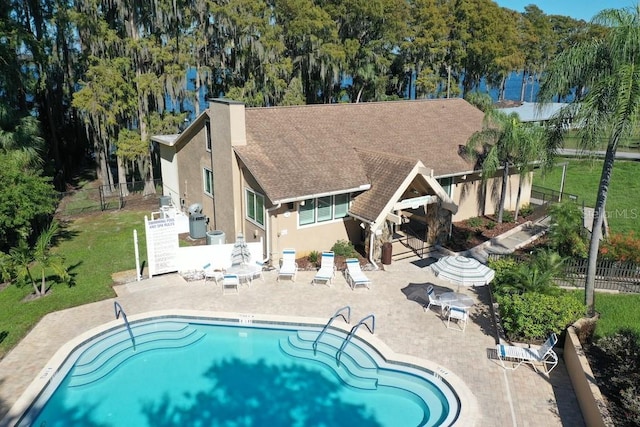 view of pool featuring a water view and a patio