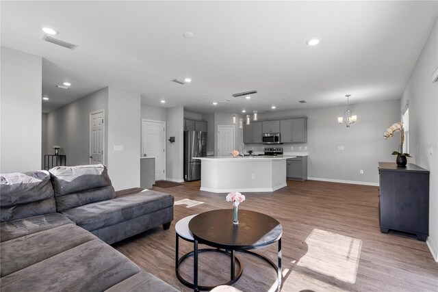 living room with wood-type flooring and a chandelier