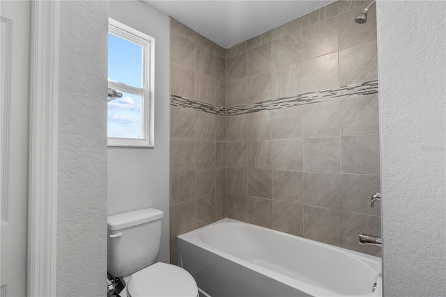 bathroom with toilet and tiled shower / bath combo