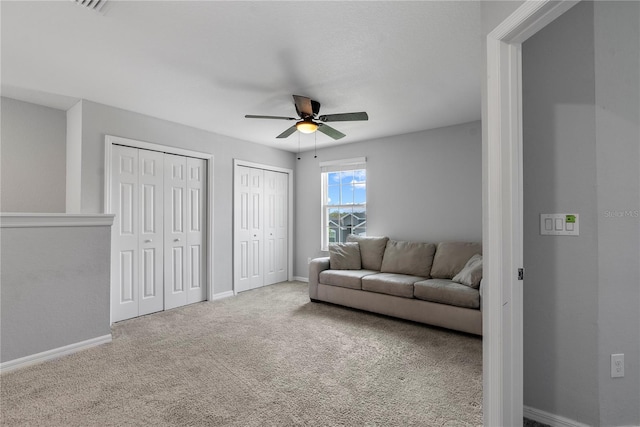 carpeted living room with ceiling fan