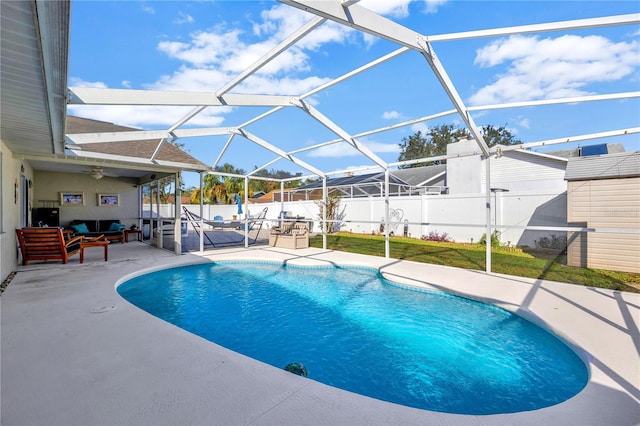 view of swimming pool with an outdoor hangout area, a patio area, glass enclosure, and ceiling fan