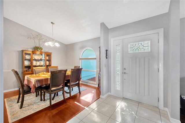 tiled entryway with an inviting chandelier