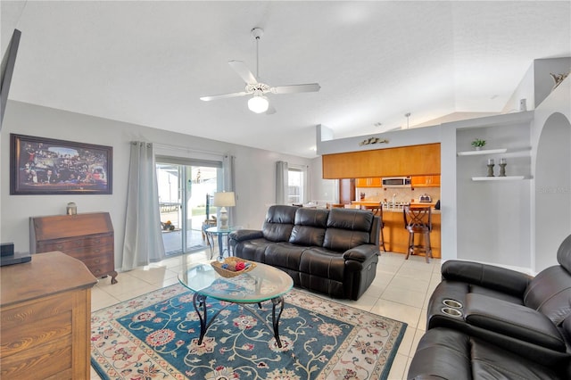 living room featuring vaulted ceiling, light tile patterned floors, ceiling fan, and a textured ceiling