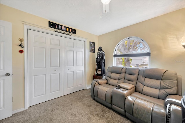 interior space featuring a textured ceiling, light carpet, and ceiling fan