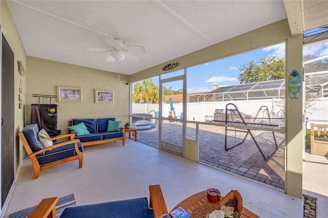 sunroom with plenty of natural light, a water view, and ceiling fan