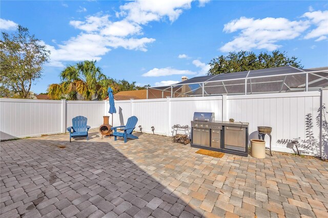 view of patio with a lanai, area for grilling, and grilling area