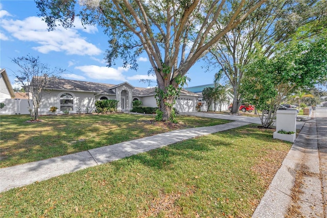 single story home featuring a front lawn and a garage