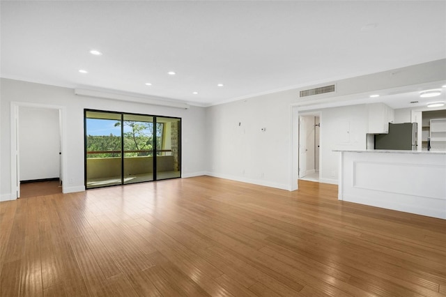 unfurnished living room with light hardwood / wood-style floors and ornamental molding