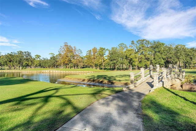 view of property's community with a lawn and a water view