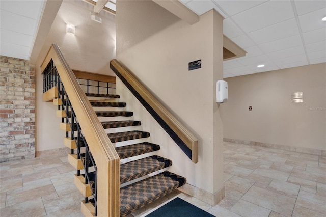 staircase featuring a drop ceiling