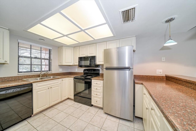 kitchen with black appliances, decorative light fixtures, light tile patterned floors, and sink