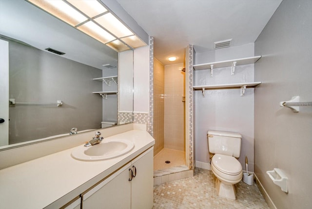 bathroom featuring tile patterned flooring, vanity, tiled shower, and toilet