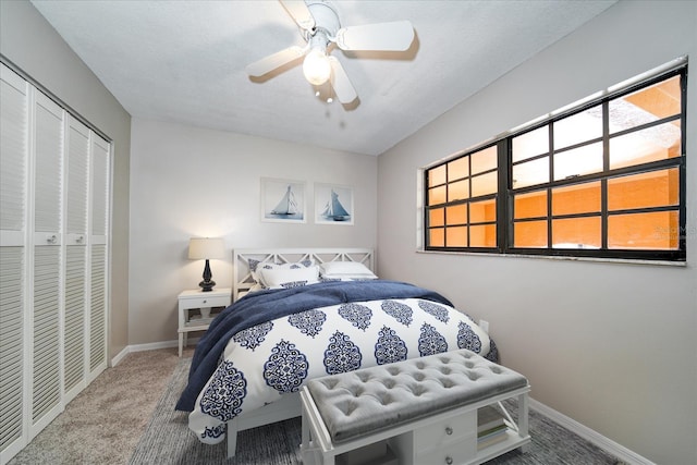 carpeted bedroom with ceiling fan, multiple windows, and a closet