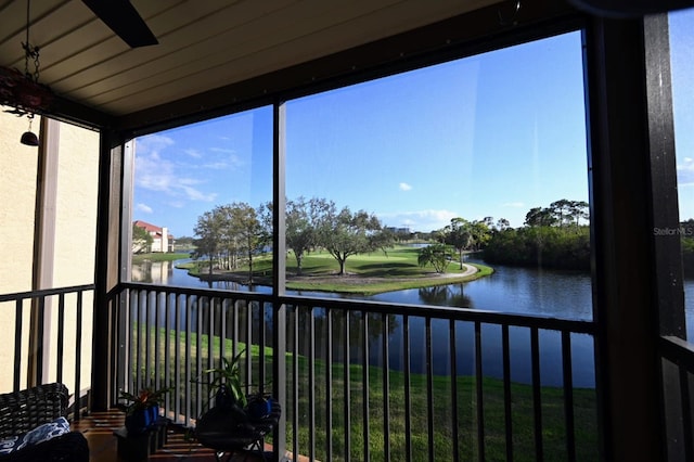 sunroom featuring a water view